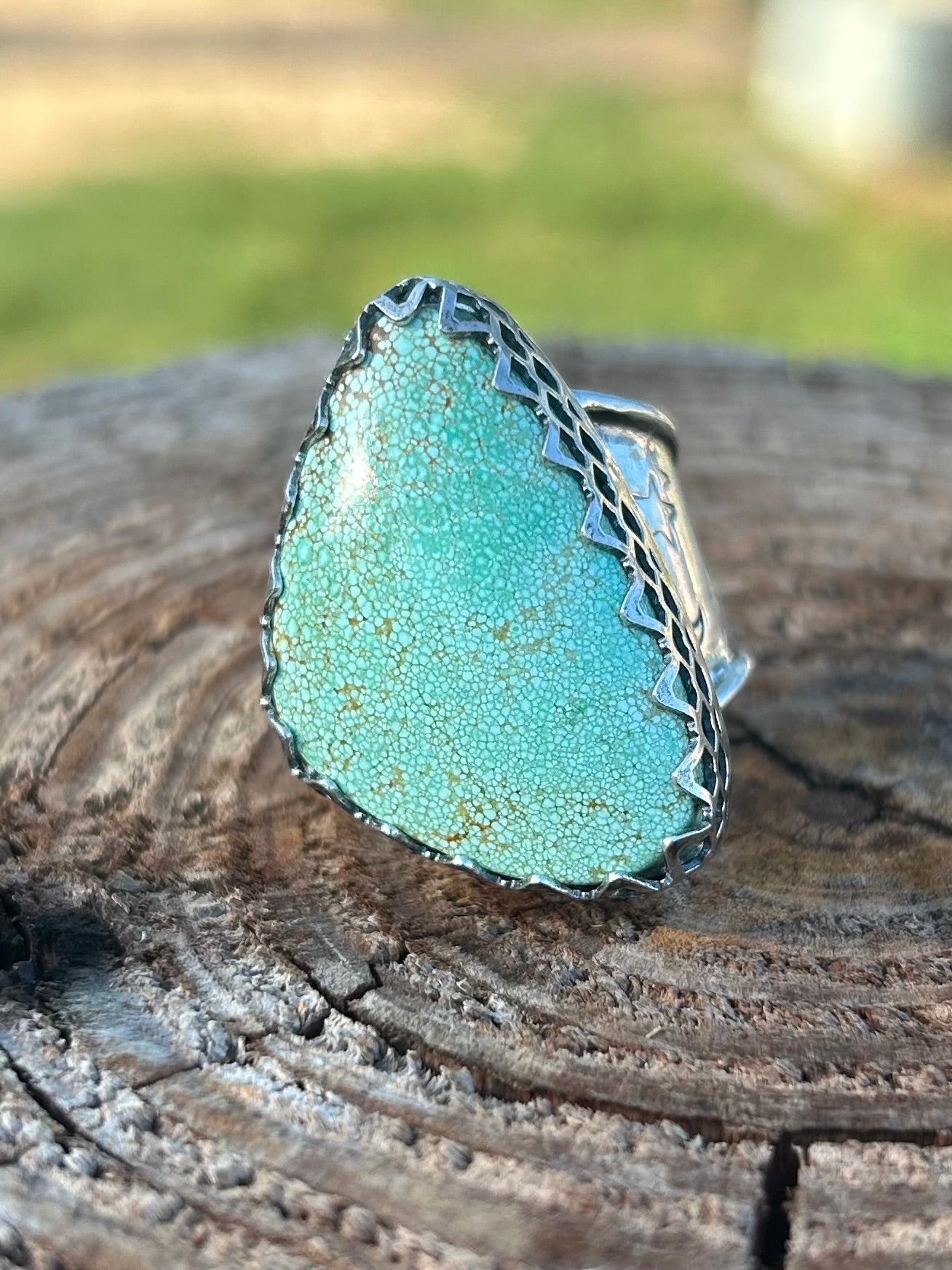 Turquoise ring with silver band on a wooden surface